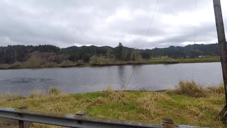 Conduciendo-Junto-A-Un-Río-Con-Pilares-A-Los-Que-Amarrarían-Troncos