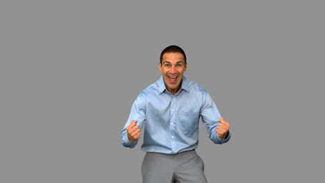 un hombre de negocios alegre haciendo gestos en la pantalla gris.