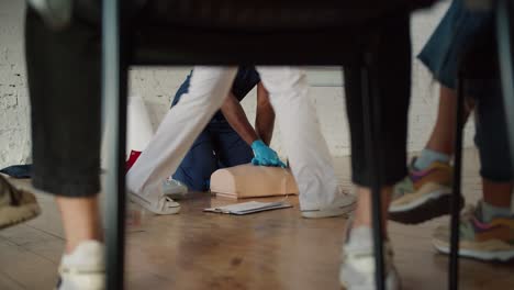 Bottom-view:-A-Black-male-doctor-in-a-blue-uniform-conducts-a-training-practical-training-on-artificial-respiration-together-with-his-assistant-in-a-white-uniform