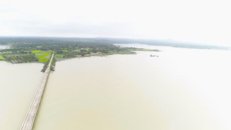 Toma-Aérea-En-Círculos-Del-Puente-Sobre-El-Río-Durante-El-Día