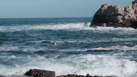 Atleta-En-Un-Kayak-Remando-Más-Allá-De-Las-Olas-Hacia-El-Océano