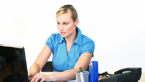 mujer de negocios rubia usando una computadora portátil en la oficina