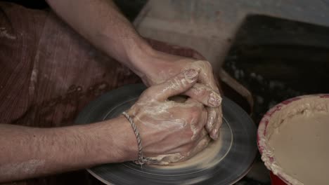 the potter makes a jug of clay. ceramist. a man makes a vase on a potter's wheel