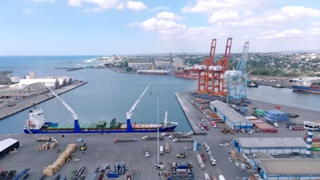 cargo ship with tall cranes and containers in background at haina port in santo domingo, dominican republic