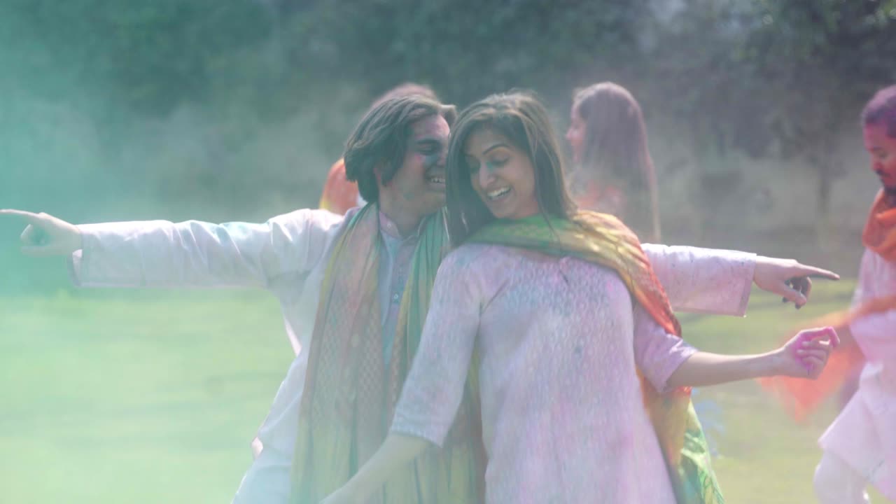 인도 부부 가 공중 에 홀리 색 을 던지고 축제를 축하 하고 있다