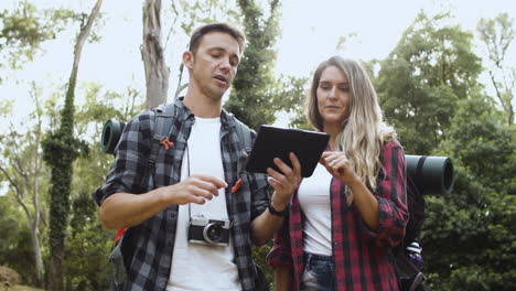 Un-Par-De-Jóvenes-Mochileros-Revisando-La-Ruta-En-Una-Tableta