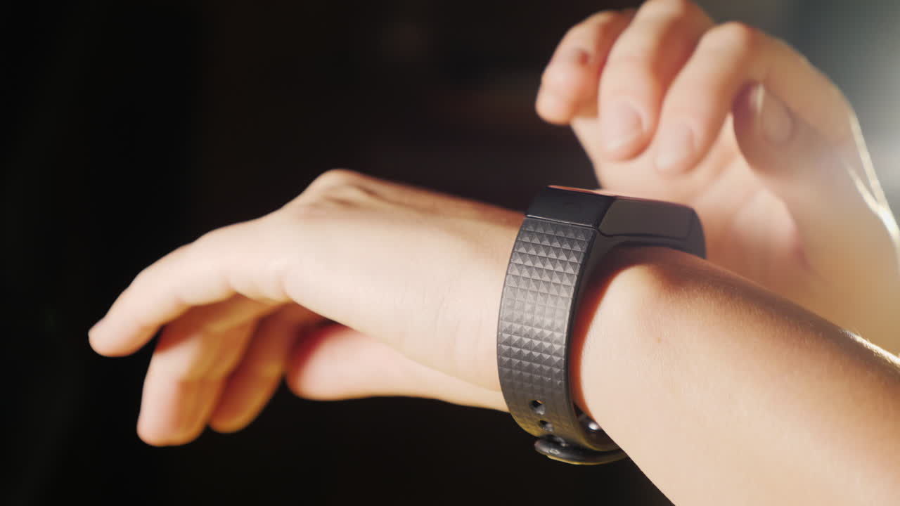 mujer disfruta de un primer plano de reloj inteligente en un fondo negro