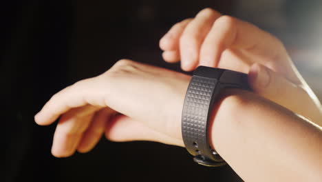 woman enjoys a smart clock close-up on a black background