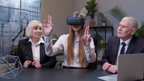 woman wearing virtual reality glasses tries 3d app for vr helmet while colleagues supporting her