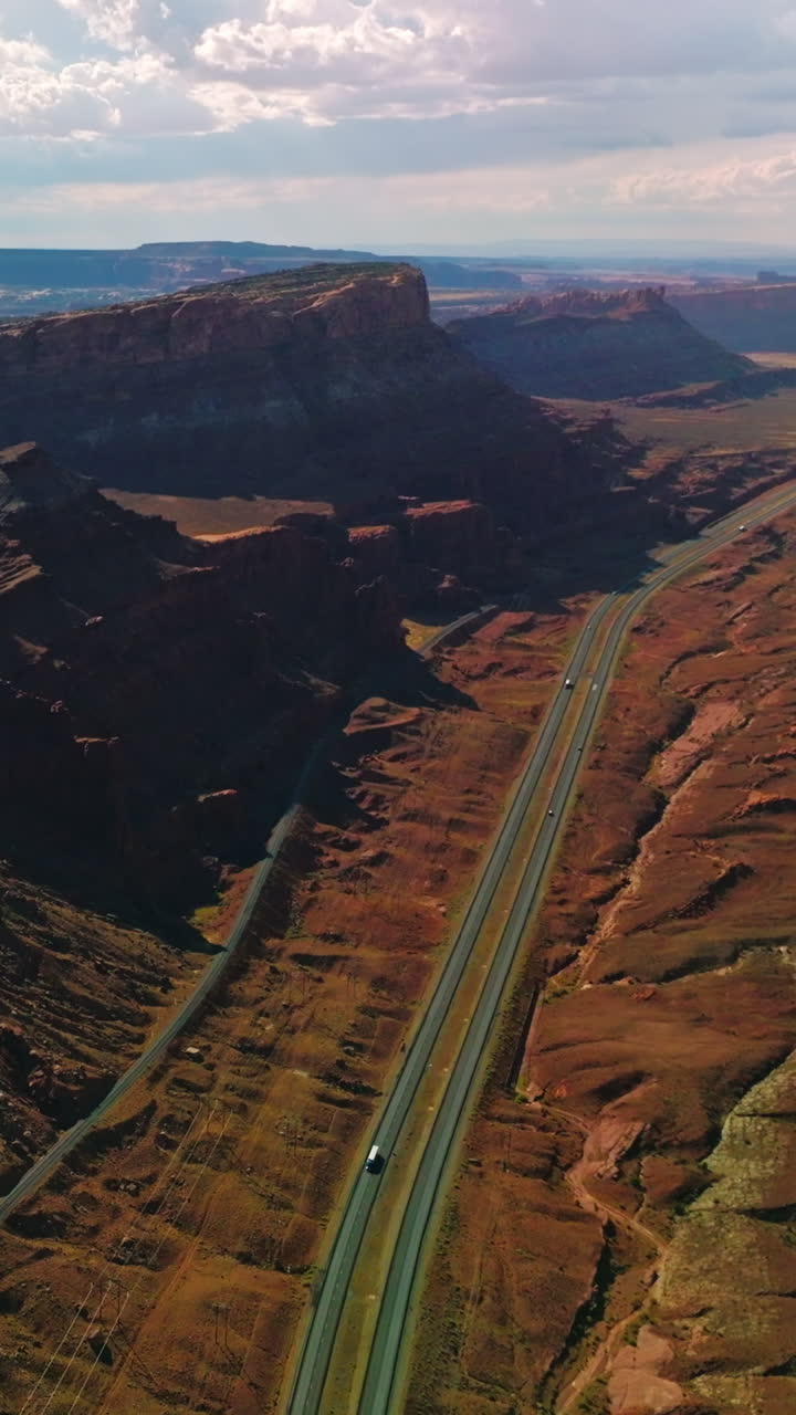 Spectacular view of huge rocks in the national park of Utah, USA. Roads passing through the canyons on sunny hot day. Aerial view. Vertical video