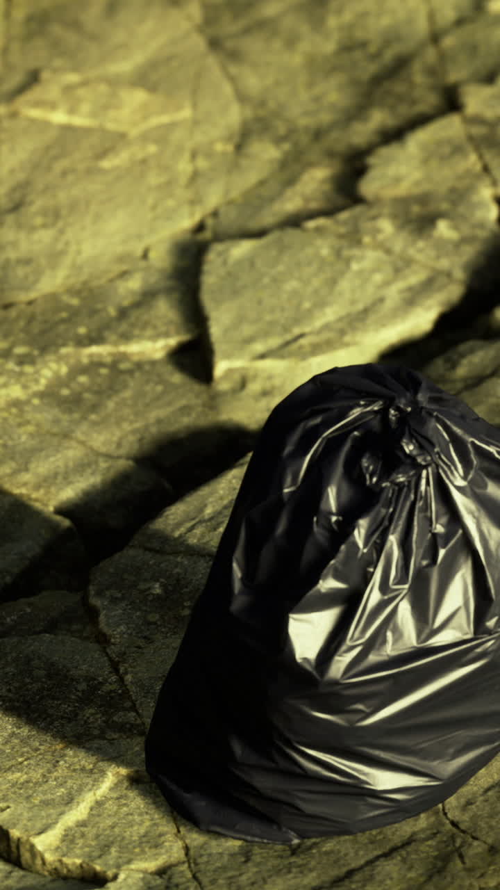 Terra screpolata sotto la luce intensa del sole: un solitario sacchetto di plastica nero si trova su un terreno arido