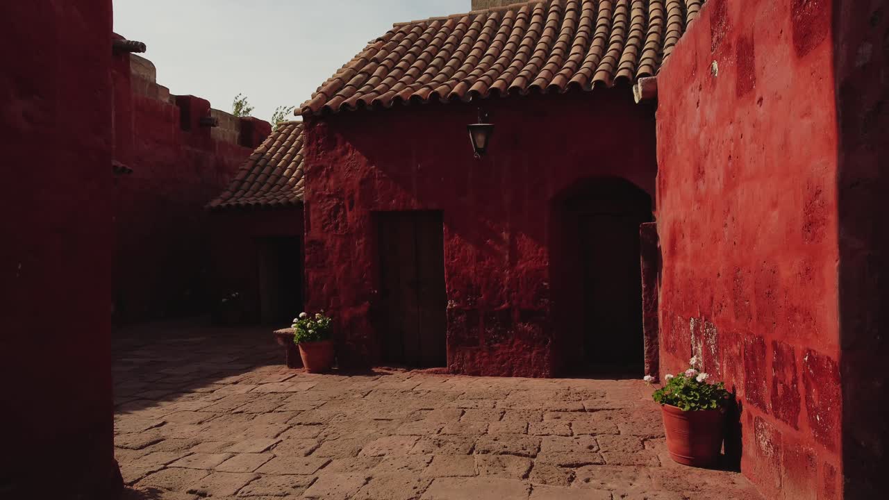 Panoramica Lenta di Vivaci Edifici Coloniali Rossi in un Cortile Storico