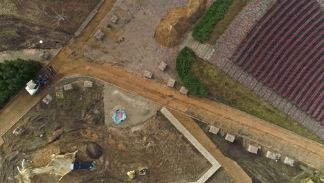 an aerial shot of a construction site and a construction vehicle moving on a driveway