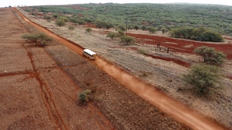 Vista-Aérea-over-a-school-bus-traveling-on-a-generic-rural-dirt-road-on-Molokai-Hawaii-from-Maunaloa-to-Hale-o-Lono