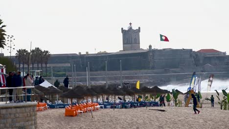 plano general del gran evento llamado &quot;capitulo perfeito&quot; con los mejores tube riders en la playa de carcavelos con el fuerte san julian detrás