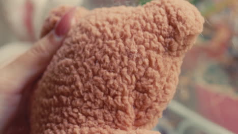 close-up of a hand holding a teddy bear
