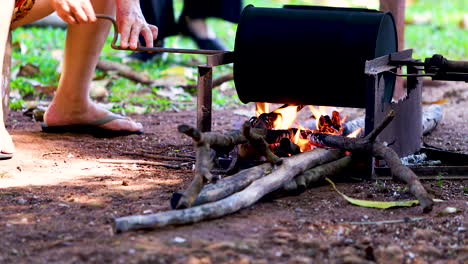 persona tostando café a la manera de la vieja granja, tostador manual, fuego de leña