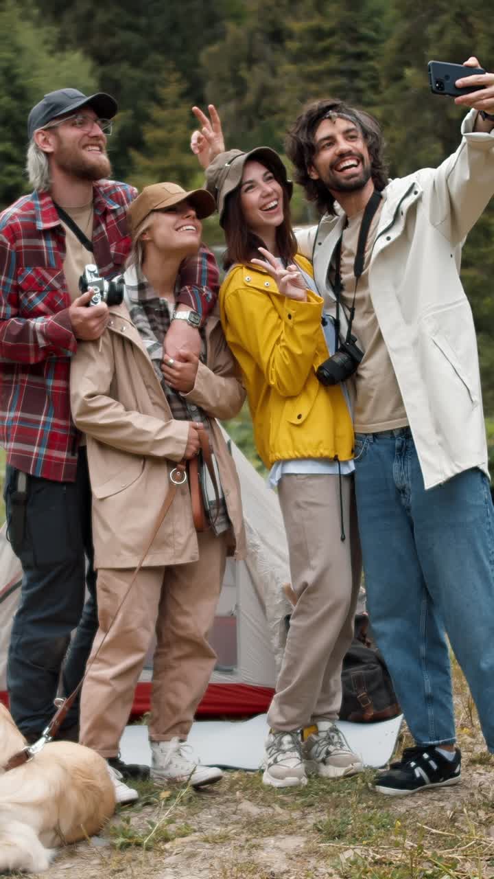 Amici che si fanno un selfie mentre campeggiano in montagna