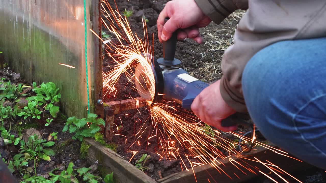 은 금속 온실을 자르는 각 도자기를 가진 남자의 클로즈업입니다.