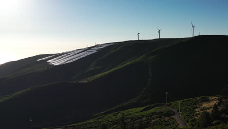 wind turbines and solar panels on sunny hill of madeira island, portugal, drone aerial view, green alternative sustainable energy concept