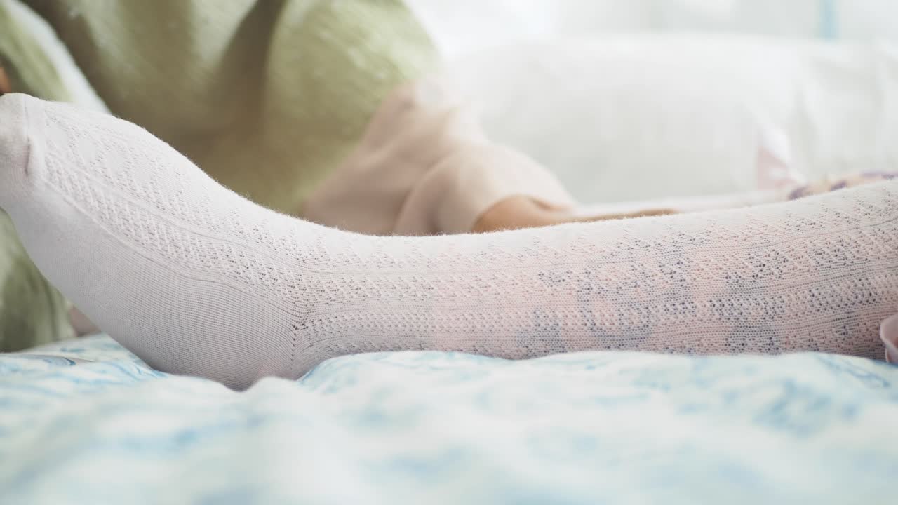 un padre poniendo calcetines en los pies de su bebé