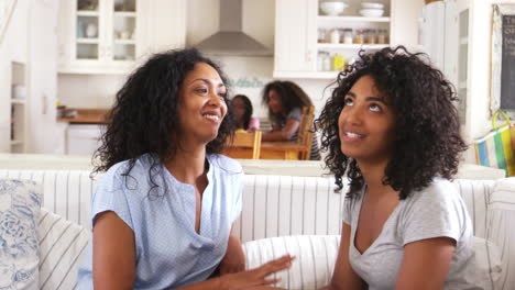 Mother-Talking-With-Teenage-Daughter-Sitting-On-Sofa-Together