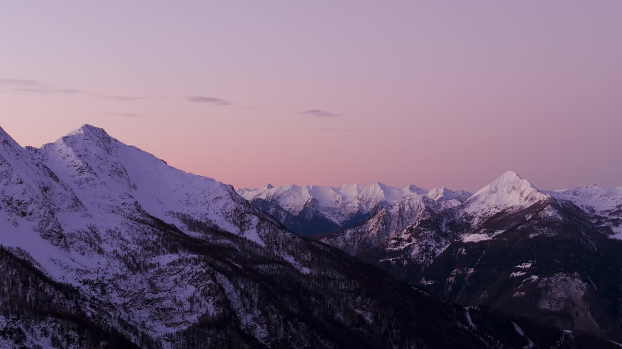 Cielo rosa al tramonto sulle Alpi innevate in inverno