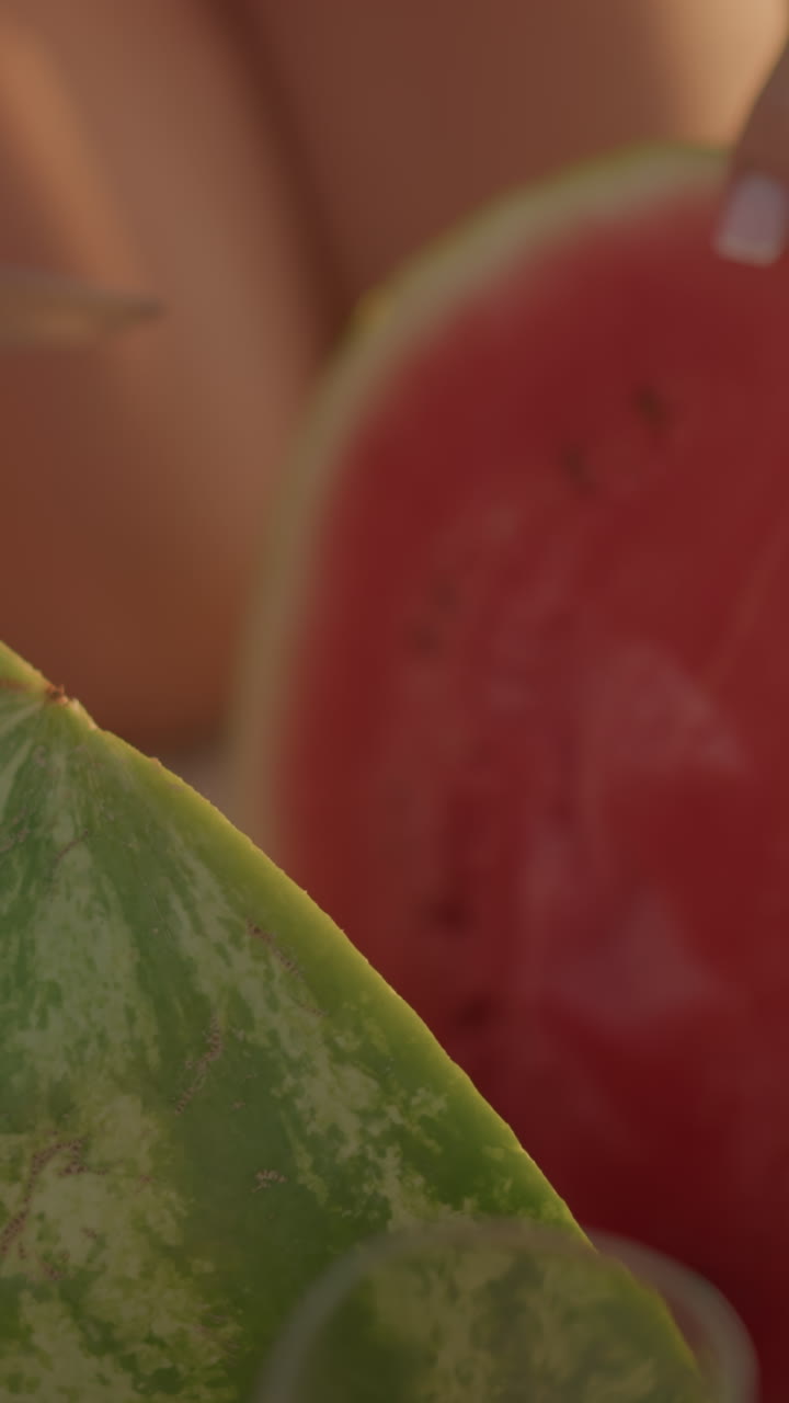 primer plano de una vibrante sandía roja cortada abierta, que muestra un interior jugoso con semillas, rodeada de un ambiente de verano, la corteza verde contrasta maravillosamente con la carne roja