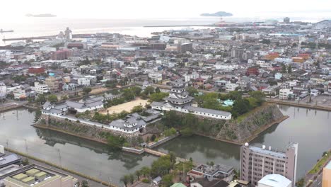castillo y ciudad de imabari, toma aérea de revelación de inclinación, japón