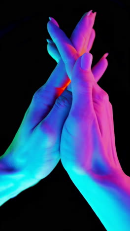 vibrant neon lit hands in abstract gestures