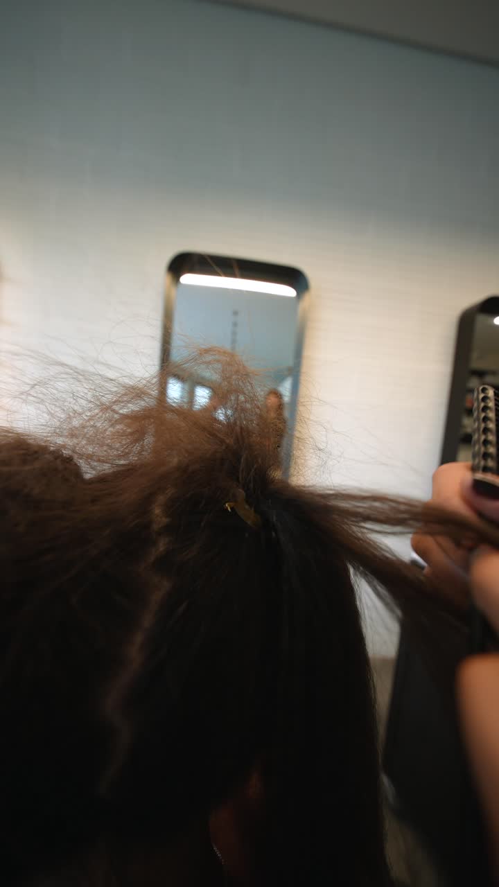 Estilista profesional peinando y seccionando el cabello de una clienta