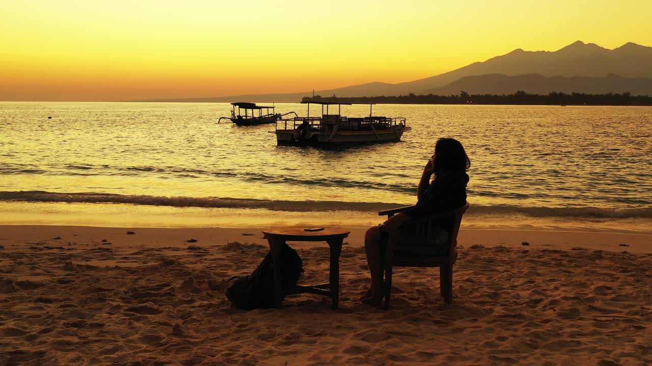 해변 바에서 태국에서 일몰을 즐기는 젊은 여자