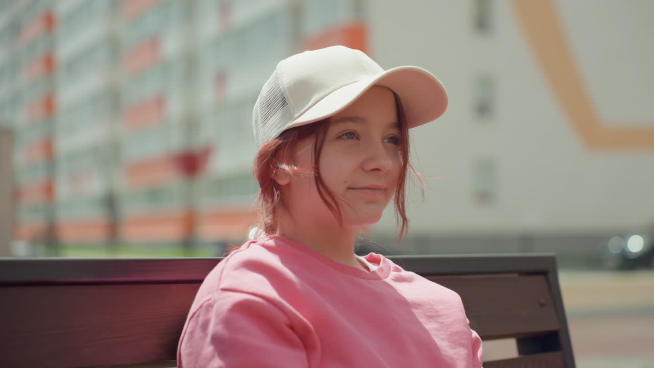 Young Person Relaxing Outside Smiling, Youthful Individual Smiling And Enjoying Fresh Outdoor Sunlight, Young Person Exhibiting Relaxed Attitude While Seated Outside In Pleasant Afternoon Sun