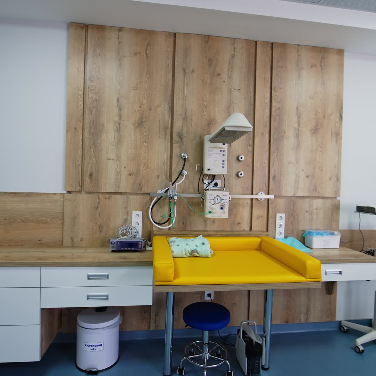 Habitación espaciosa con mobiliario y equipamiento nuevos para parturientas. Mesa pequeña para recién nacidos con dispositivos arriba.