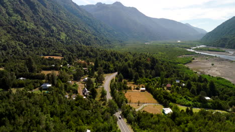 petrohué village, lush green mountain valley, river in background, southern chile. aerial forward