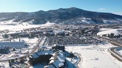 Estacionamiento-Completo-De-Autos-En-La-Estación-De-Esquí-De-La-Ciudad-Montañosa-De-Colorado-Con-Hermosos-Paisajes-Invernales---Plano-Aéreo-De-Drones