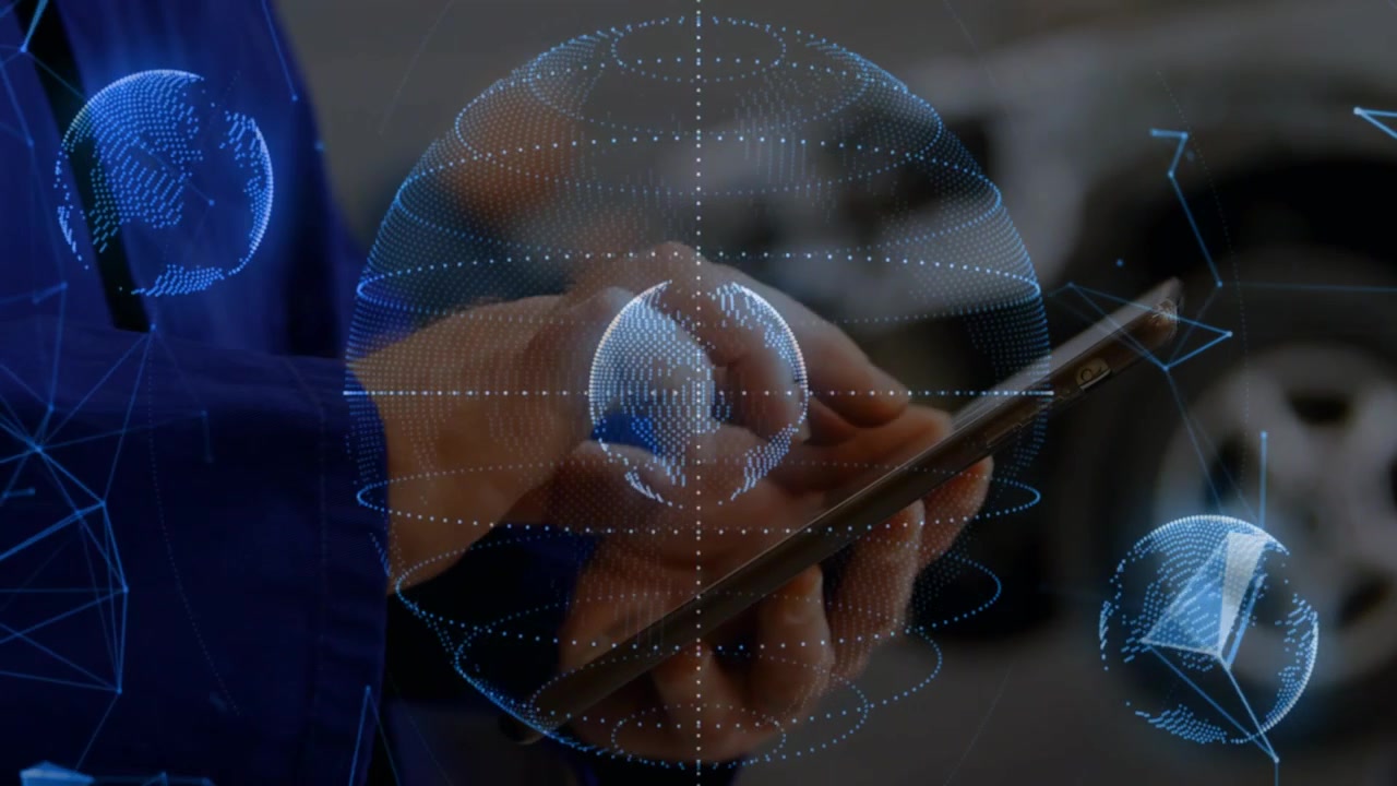 Male tech holding tablet, right finger tapping and rotating globe, inspecting auto data near wheel