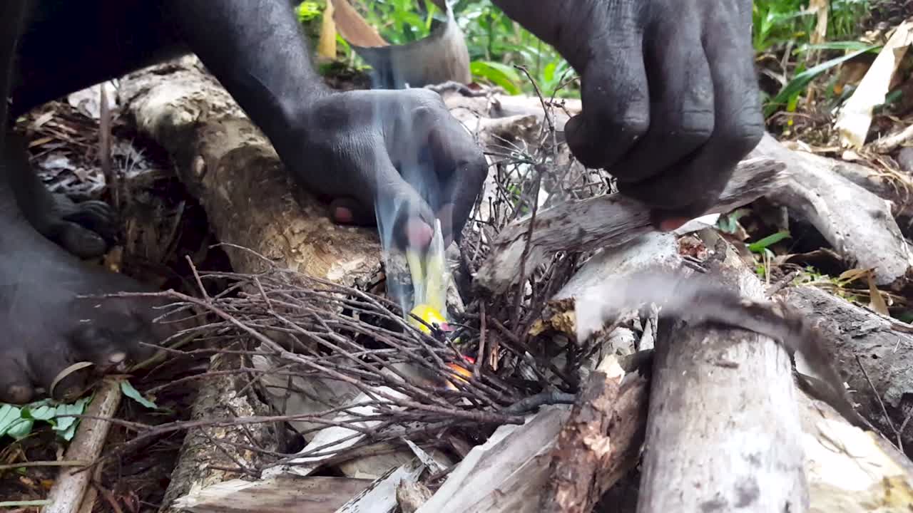 Menyalakan api unggun di luar ruangan dengan kantong plastik, keterampilan bertahan hidup, saat mendaki semalam di hutan hujan belantara di pulau tropis terpencil