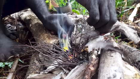 starting an outdoor open fire with a plastic bag, survival skills, on an overnight hike in the wilderness rainforest on a remote tropical island