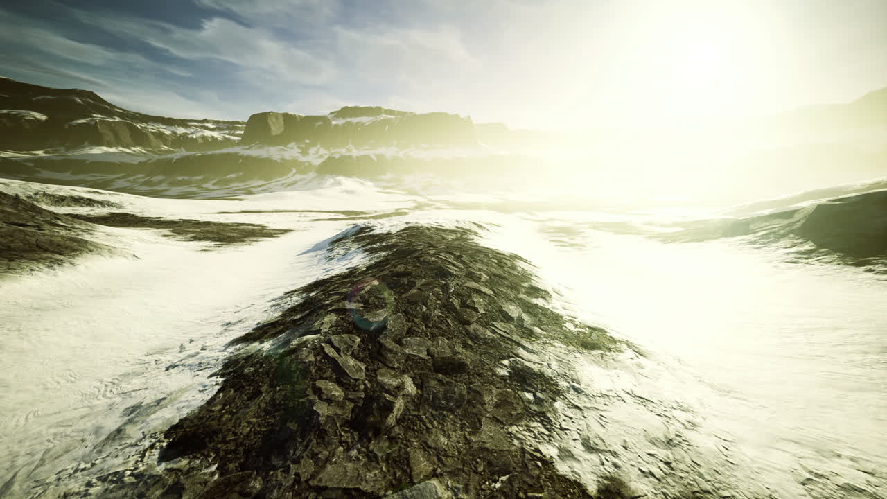 A vast rocky landscape stretches under a brilliant sun