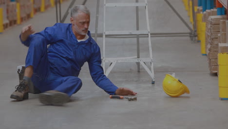 animation of scratches over caucasian senior man falling from ladder in warehouse