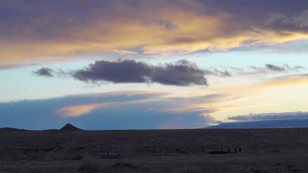 Surreal desert sunset with dramatic clouds and rich sky colors, slowed for a dreamlike cinematic effect. Ideal for travel films, sci-fi mood shots, westerns, and atmospheric storytelling
