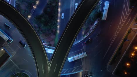 iluminación nocturna de la ciudad de qingdao tráfico ocupado intersección de carreteras panorámica aérea de arriba hacia abajo 4k china