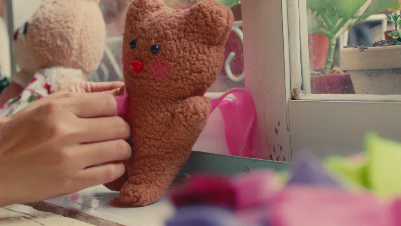 Child cleaning window with teddy bear