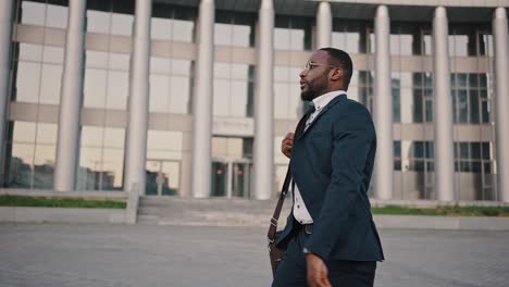 late to meeting. young african american man going to office, looking at watch and realizing he is late, keep hurrying