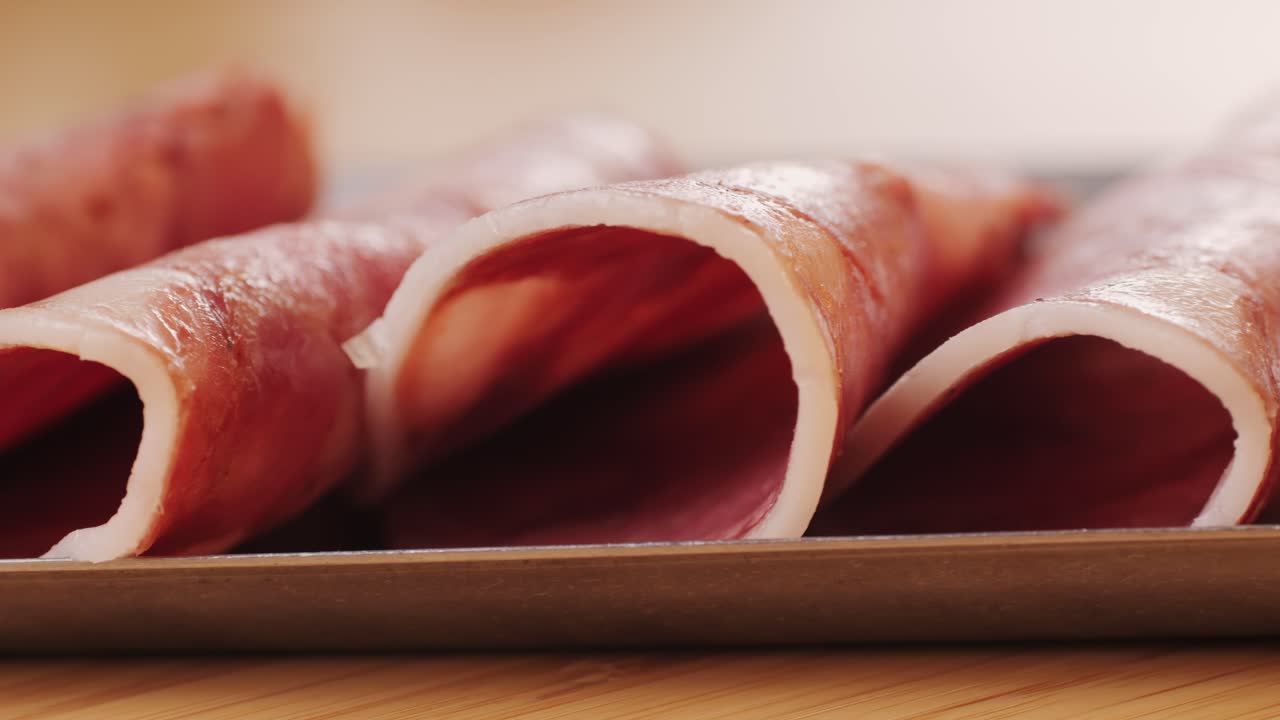black bull sausage ham, tongue pork dry-cured sausage on a black background, traditional spanish delicatessen food, close up.