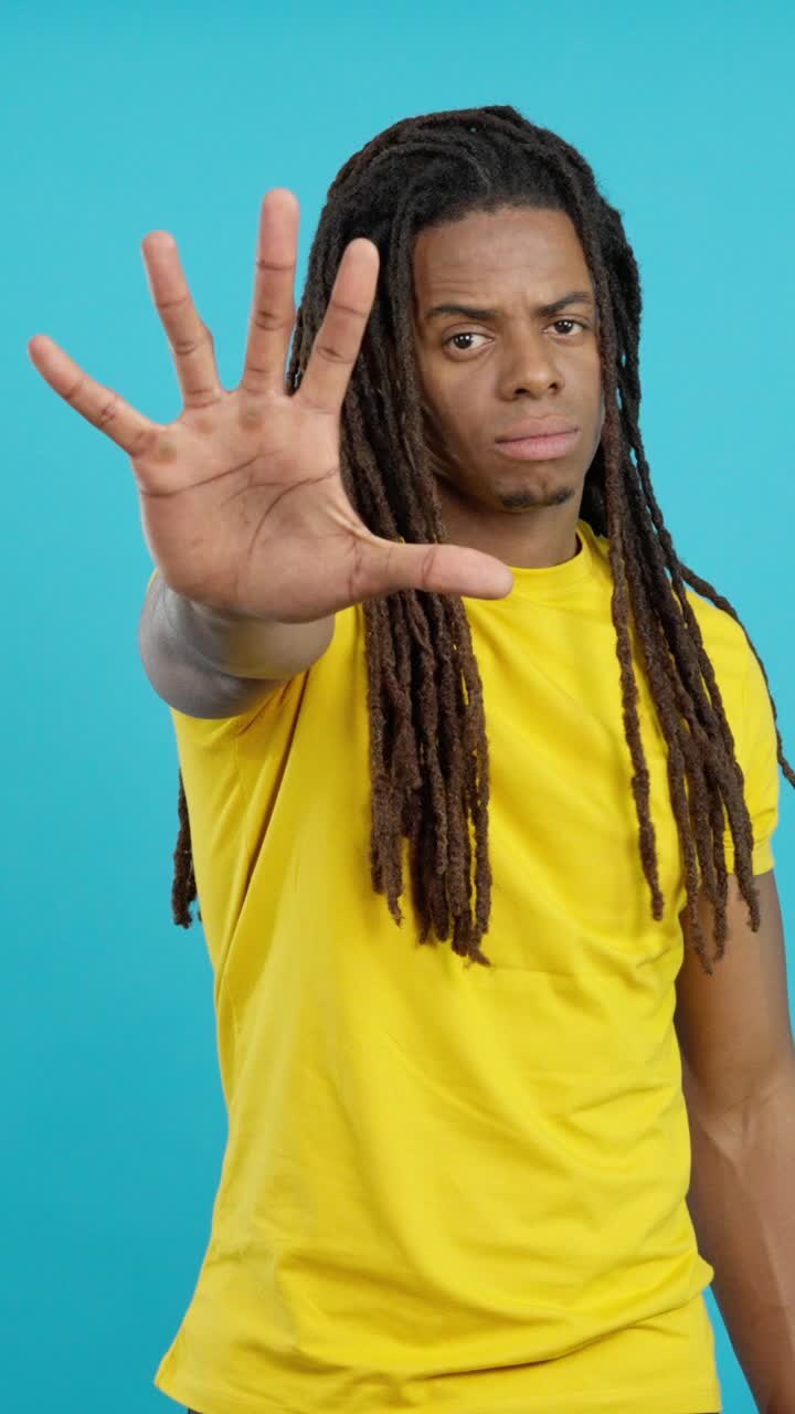 Uomo con i dreadlock con la mano alzata