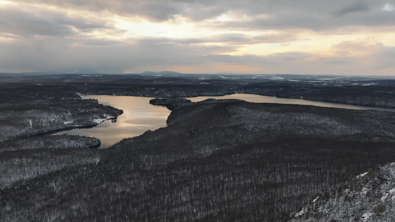 озеро в окружении заснеженных лесных гор в сумерках в орфорде, канада