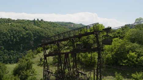 Viejo-Y-Oxidado-Pilón-De-Teleférico-De-Carga-En-La-Ladera-Boscosa,-Chiatura,-Georgia