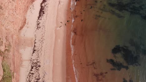 vista aérea de las olas rompiendo suavemente en la playa vacía en devon